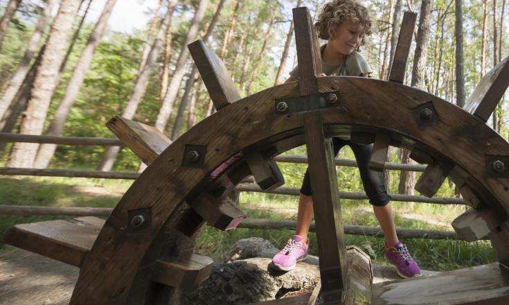 A kid next to a water wheel